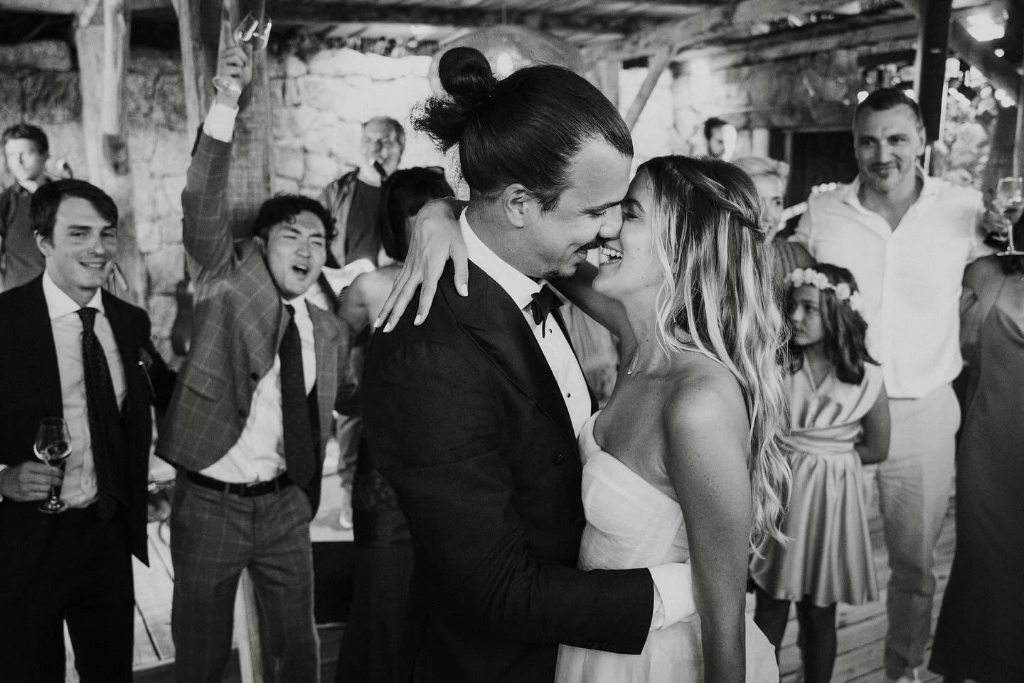Couple de mariés riant spontanément pendant leur séance photo à Lagnonu entourés de leurs invités
