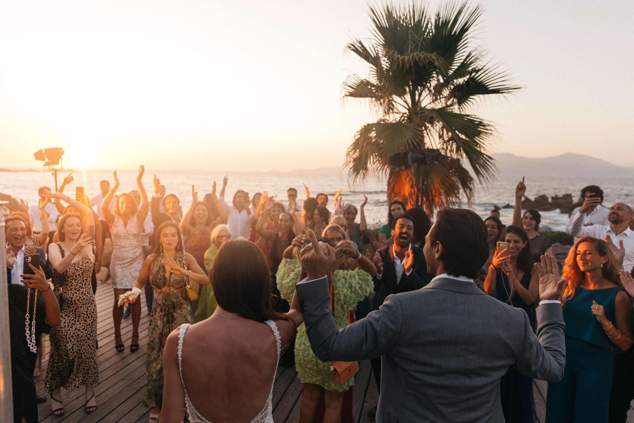 Mariés et invités dansant sous le couché de soleil du domaine Lagnonu